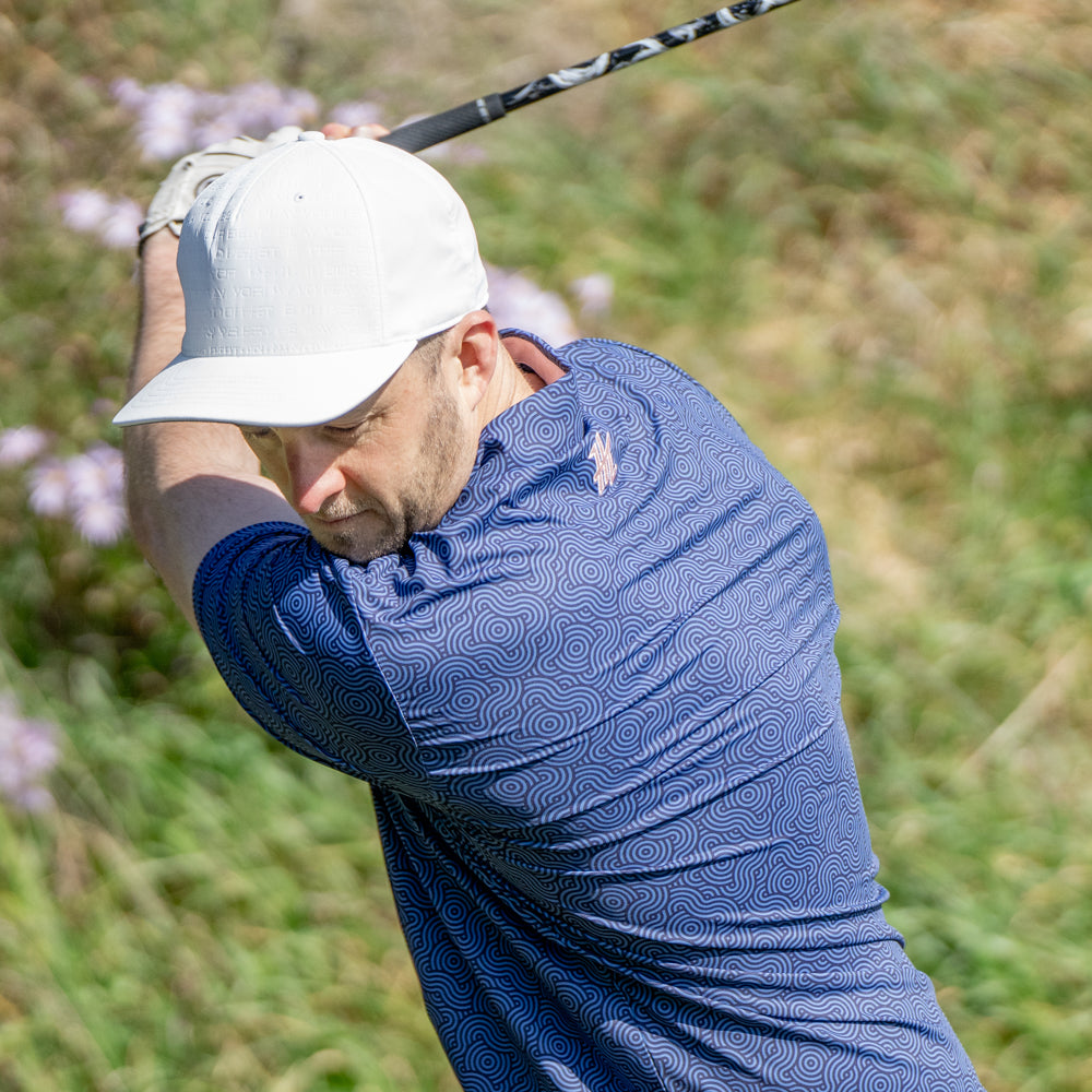 Male hitting a golf shot in the Ripple Effect Polo by High Cut Golf NZ